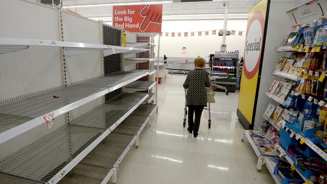 An elderly shopper walks down the empty aisle where the stock of toilet paper has sold out in Coles, Westfield, Bondi Junction. Picture: Jeremy Piper