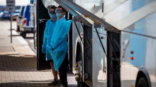 Workers prepare to bus passengers from Darwin Airport to Howard Springs. Picture: Che Chorley