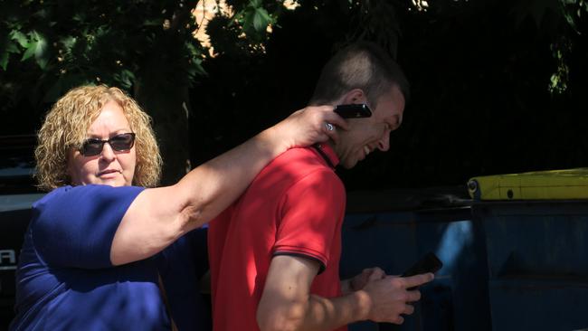 Joshua Crowe was supported by a woman as he ducked for cover outside Dubbo Local Court. Picture: Ryan Young