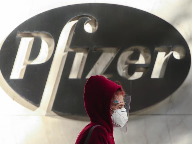 A woman wears a facemask as she walks by the Pfizer world headquarters in New York on November 9, 2020. - Pfizer stock surged higher on November 9, 2020 prior to the opening of Wall Street trading after the company announced its vaccine is "90 percent effective" against Covid-19 infections. The news cheered markets worldwide, especially as coronavirus cases are spiking, forcing millions of people back into lockdown. (Photo by Kena Betancur / AFP)