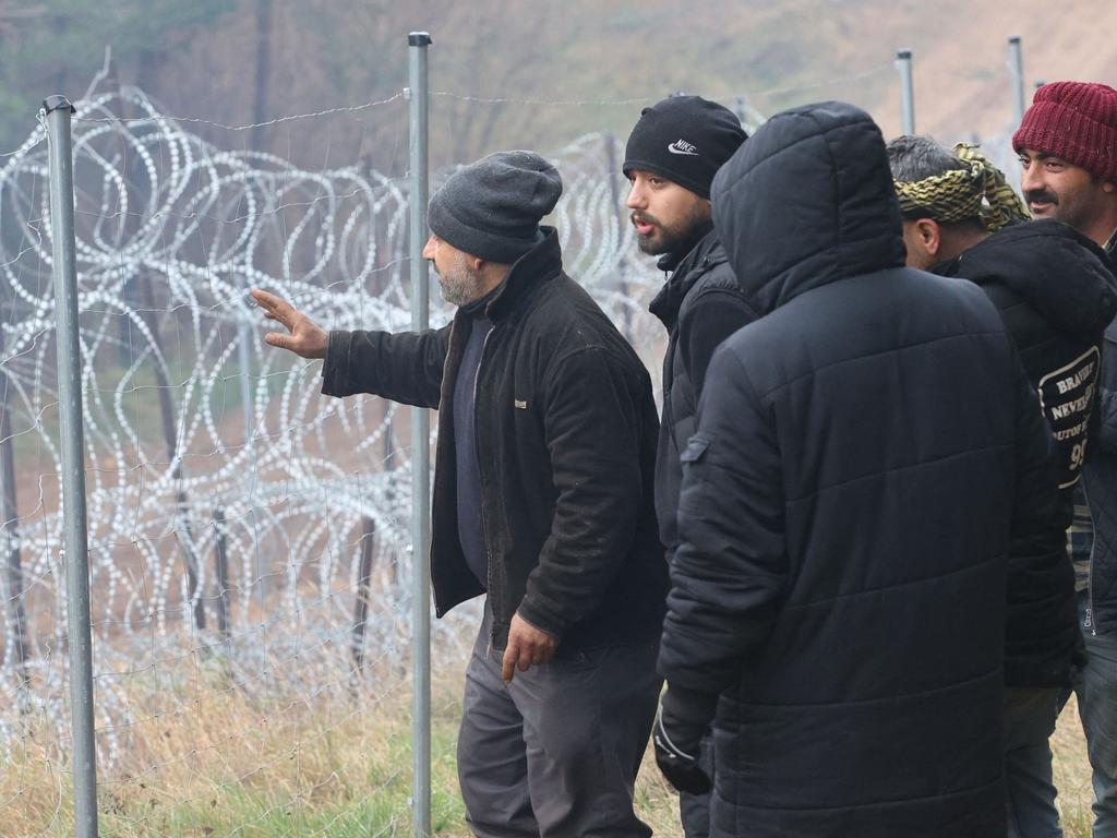 Migrants near a barbed wire fence on the Belarusian-Polish border. Picture: Leonid Shcheglov/BELTA/AFP