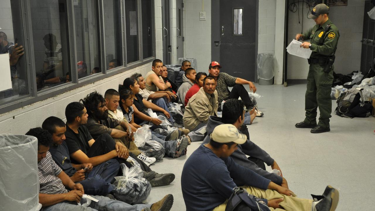 Suspected illegal immigrants lined up along the wall in the processing facility. Picture: NGTV