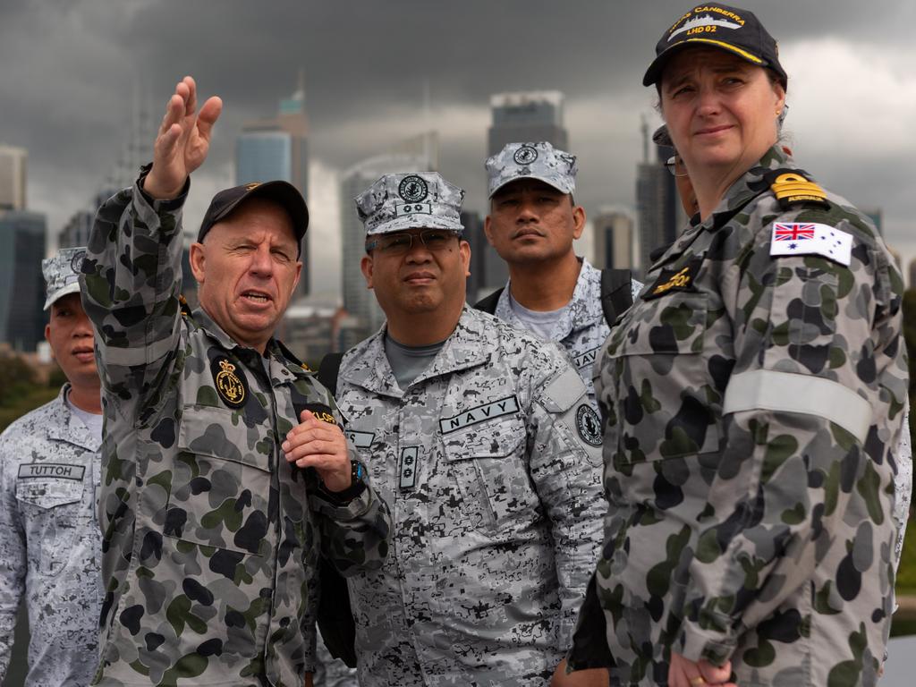 Royal Australian Navy and Philippine Navy officers on the flight deck of HMAS Canberra during a Maritime Training Activity. Picture: Australian Defence Force