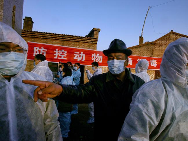 Chinese health workers tend a prevention of animal epidemic, disinfection and inspection check point in one of the entrances to the area of the farm in the northern grasslands of the Inner Mongolia region that suffered the first of four outbreaks reported over the past month in China, in Tengjiaying, Thursday, Nov. 3, 2005. China reported its fourth bird flu outbreak in three weeks, saying the virus killed 8,940 chickens in a village in the country's northeast and prompted authorities to destroy 369,900 other birds. The outbreak occurred Oct. 26 in Badaohao, a village in Liaoning province, east of Beijing, the Agriculture Ministry said in a report posted late Thursday on the Web site of the Paris-based World Organization for Animal Health.