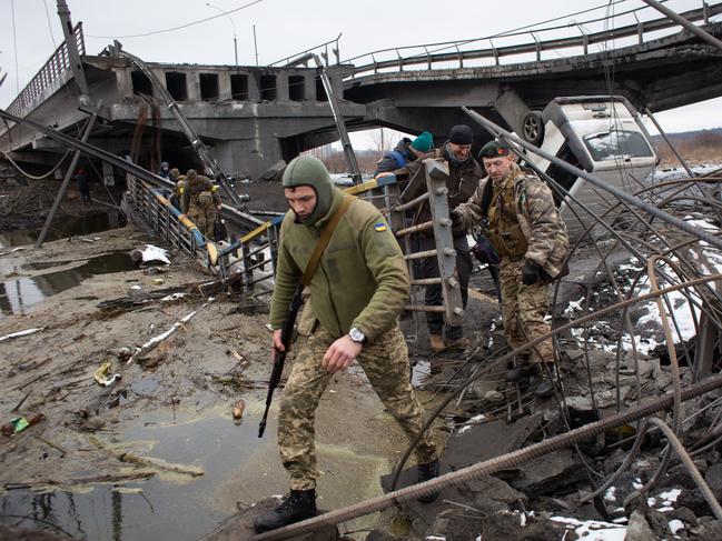 Ukrainian serviceman cross the destroyed bridge in Irpin, Ukraine. Picture: Anastasia Vlasova/Getty Images