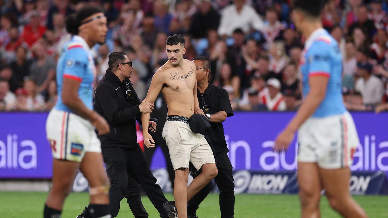 A pitch invader is taken off the field by security.