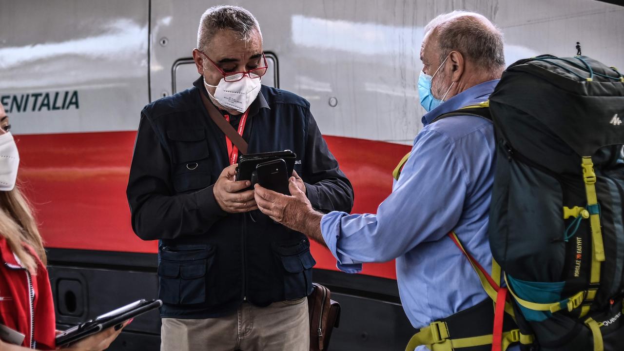 An inspector (L) checks a passenger boarding the train, for his so-called Green Pass. Picture: Marco Bertorello / AFP