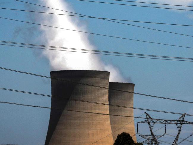 (FILES) This photo taken on December 13, 2023 shows electricity lines passing near the emission funnels of the Bayswater coal-powered thermal power station near the central New South Wales town of Muswellbrook. Australia's reliance on coal-fired power stations has dropped to a record low, providing less than 50 percent of its electricity for the first time, the market operator said on January 30, 2025. (Photo by DAVID GRAY / AFP)