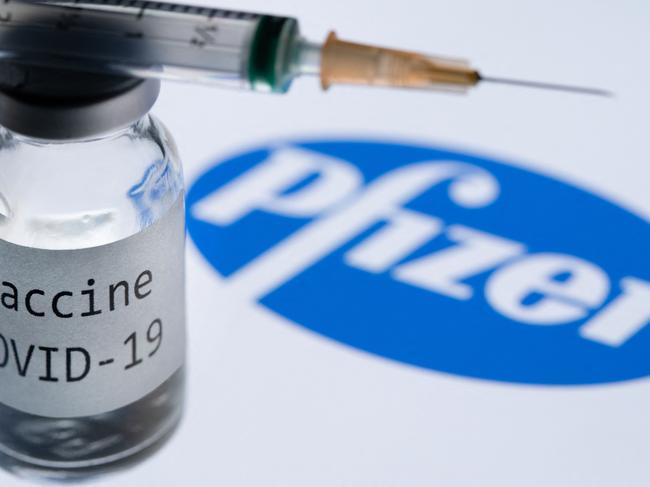 (FILES) This file photo taken on November 23, 2020 shows a syringe and a bottle reading "Covid-19 Vaccine" next to the Pfizer company logo. - Pfizer reported another quarter of huge revenues growth because of the Covid-19 vaccine on May 3, 2022, but lowered its full-year profit forecast due in part to shifts in foreign exchange. (Photo by JOEL SAGET / AFP)
