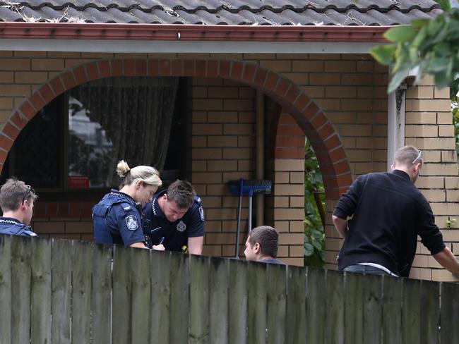 Rapid Action Police team members speak to the occupants of a unit in Nerang during a raid on the Gold Coast.