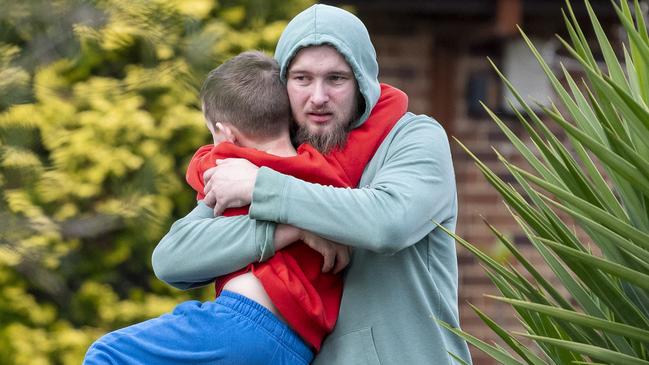 Neighbour Jarrod Hawkins - pictured hugging his son - has been hailed a hero. Picture: NewsWire / Simon Bullard.