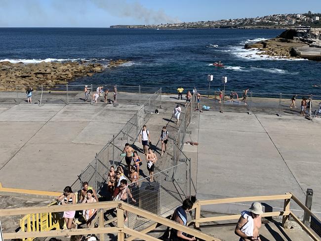 Swimmers leave Clovelly Beach after being ordered from the water by police. Picture: Getty