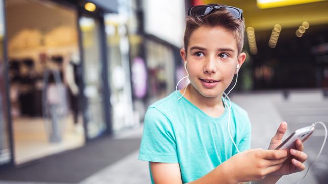 Boy with his mobile phone in a shopping center