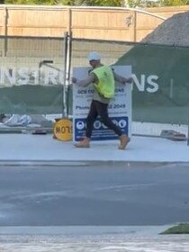 A GCB Constructions removes a GCB sign from the Drift development at Hughes Avenue, Main Beach on Friday morning May 12. Credit: Gold Coast Bulletin