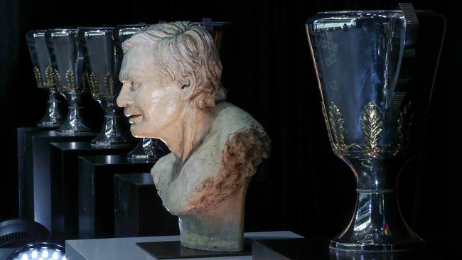 A bust of Ron Barassi pictured next to his premiership cups. Picture: Michael Klein