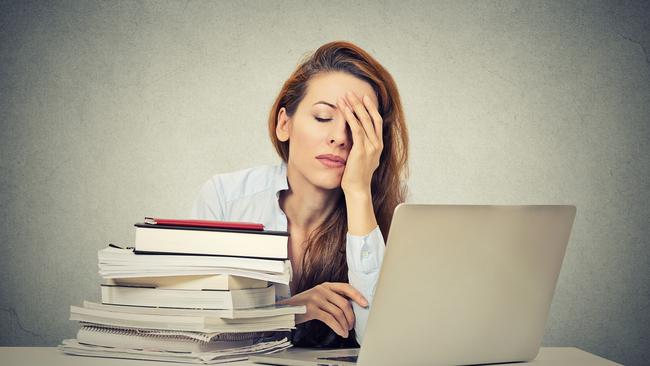 Too much work tired sleepy young woman sitting at her desk with books in front of laptop computer isolated grey wall office background. Busy schedule in college, workplace, sleep deprivation concept