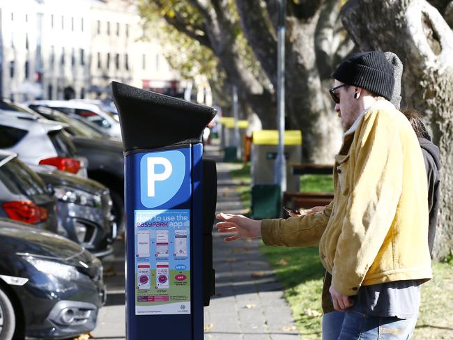 Hobart City Council is under fire about the new parking meters and how fnes are issued for offences that are not made clear.  Pictured is Joel Herron with his partner from Melbourne trying to make sense of it all.Picture: MATT THOMPSON