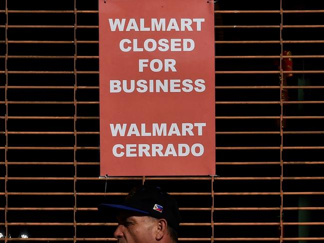 (FILES) This file photo taken on January 28, 2016 shows a closed sign at a Walmart store in Chinatown in Los Angeles, California. Wal-Mart Stores trimmed its sales forecast for fiscal 2017 February 18, 2016 due to store closures and the strong dollar as it reported lower fourth-quarter earnings.The world's biggest retailer saw shares tumble as it reported that it now expects fiscal 2017 sales to be flat, down from the previous outlook for three to four percent growth. Walmart's fiscal 2017 started February 1. / AFP / Mark Ralston