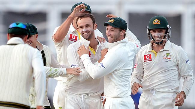 Nathan Lyon, Mike Hussey and Phil Hughes celebrate a wicket during Lyon’s Test debut.