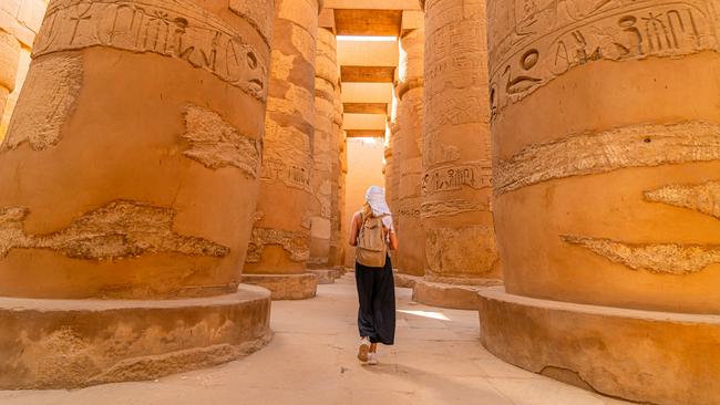 Female tourist walks between Pillars of the Great Hypostyle Hall from Karnak TempleEscape 6 October 2024Eds LetterPhoto - iStock