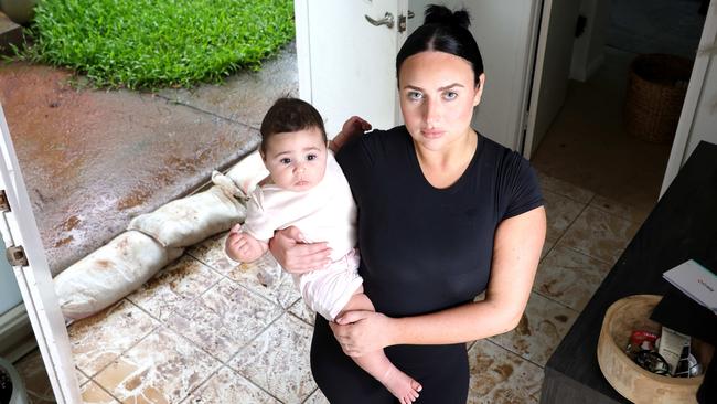 Brittany Opetaia-Halls and daughter Milana-Mae Opetaia-Halls 6months, had her house flooded yesterday because of council work in front of her place, Kallangur - on Wednesday 18th December 2024 - Photo Steve Pohlner