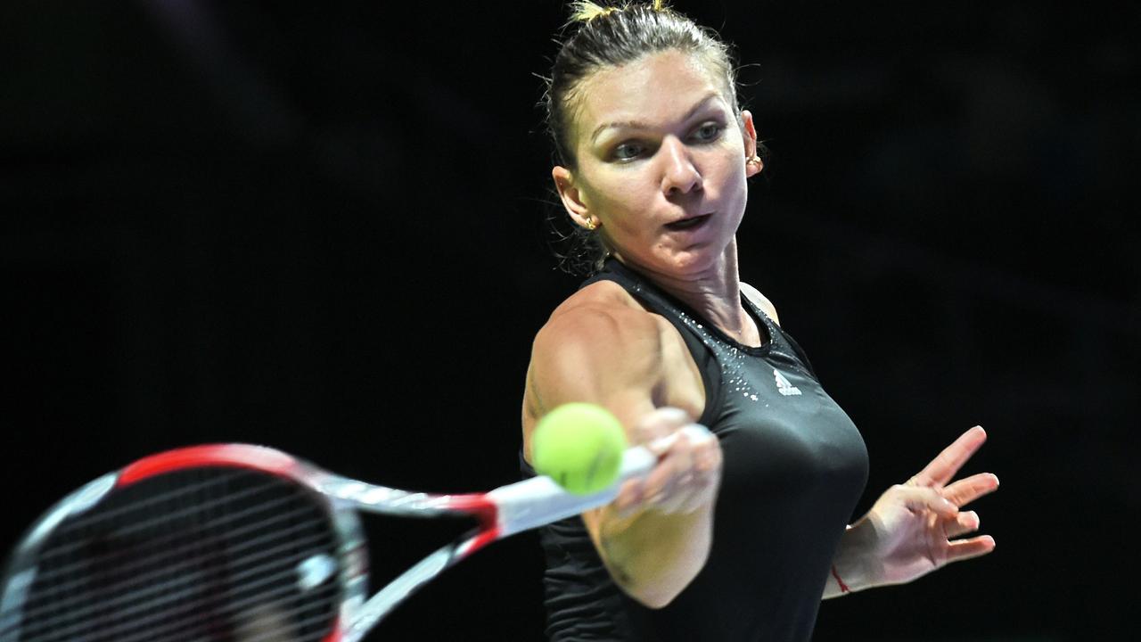(FILES) -- A picture taken on October 24, 2014 shows Simona Halep of Romania playing during the Women's Tennis Association (WTA) finals round robin match in Singapore. Romanian three tennis player Simona Halep, ranked world number 3, anounced on November 6, 2014 her amicable separation from her Belgian coach Wim Fissette. AFP PHOTO / ROSLAN RAHMAN