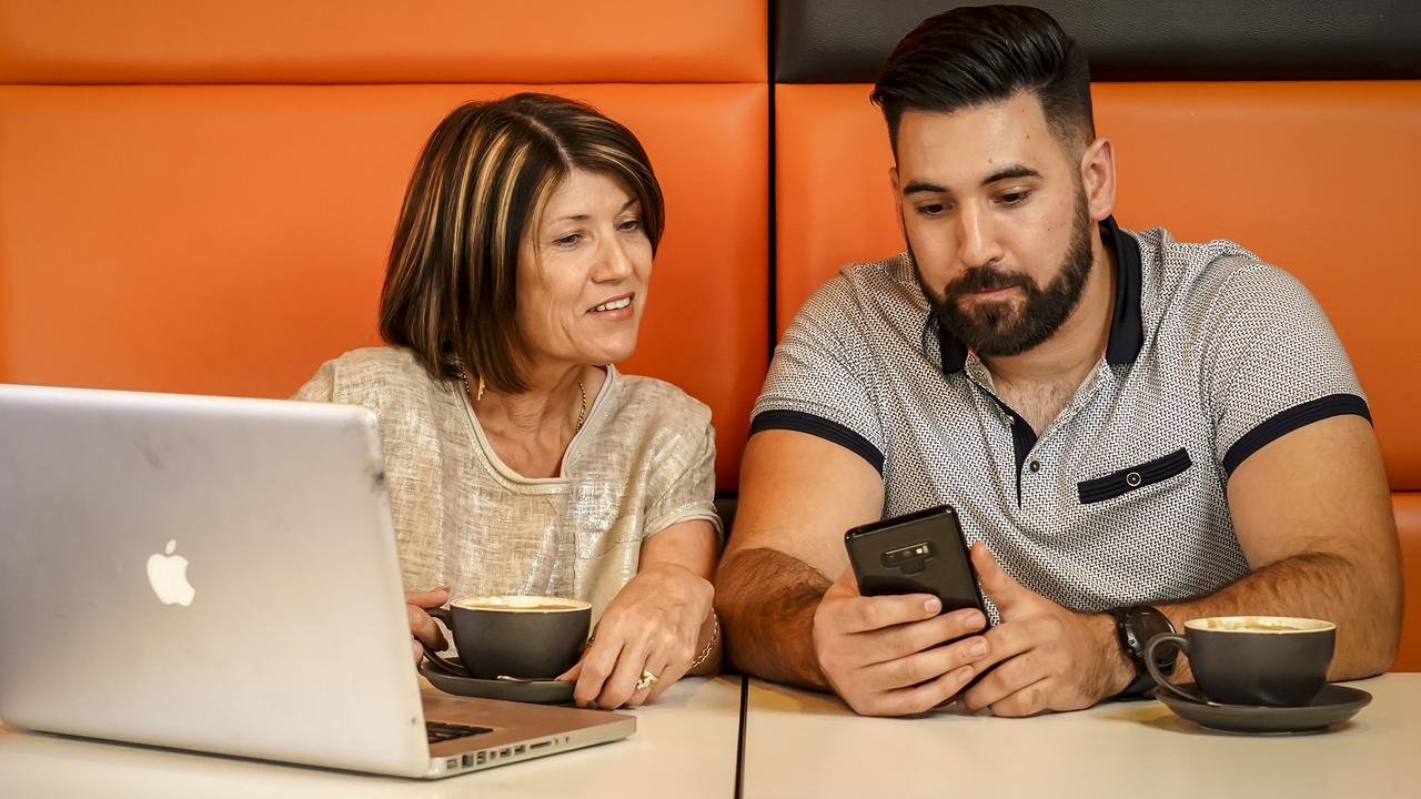 Daniel Devine shows mobile banking to his mum Sharyn Devine. Picture: AAP/Mike Burton