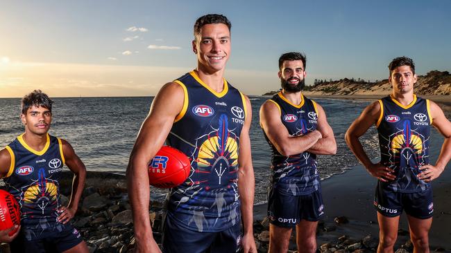 Ben Davis, front, models the 2021 Indigenous jumper he designed for the Crows with Tariek Newchurch, left, Wayne Milera and Shane McAdam, right. Picture: Sarah Reed