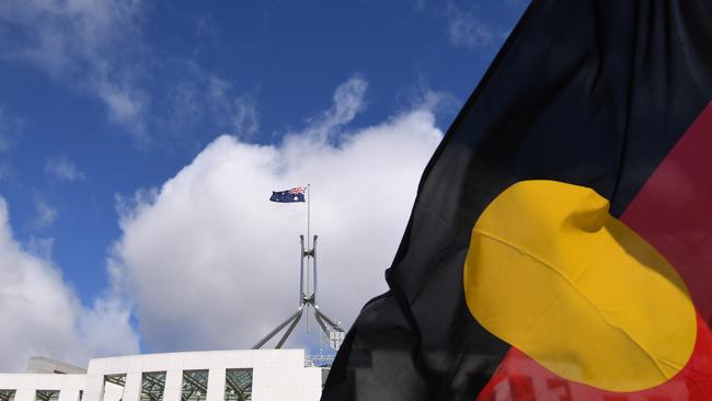 Australian Parliament House seen through an Aboriginal flag. Picture: AAP Image/Lukas Coch