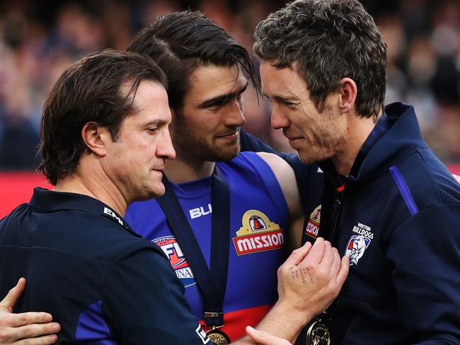 Western Bulldogs coach Luke Beveridge, Captain Easton Wood and Robert Murphy hug on stage after the Bulldogs won the AFL Grand Final between Sydney Swans v Western Bulldogs at the MCG. Picture. Phil Hillyard