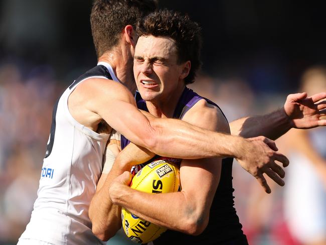 ADELAIDE, AUSTRALIA - APRIL 06: Jordan Clark of the Dockers is tackled by George Hewett of the Blues during the 2024 AFL Round 04 match between the Fremantle Dockers and the Carlton Blues at Adelaide Oval on April 06, 2024 in Adelaide, Australia. (Photo by Sarah Reed/AFL Photos via Getty Images)