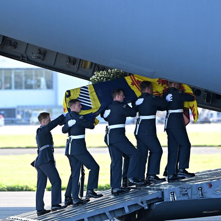 Pallbearers from the Queen's Colour Squadron of the Royal Air Force (RAF) carry the coffin of Queen Elizabeth II, draped in the Royal Standard of Scotland, into a RAF C17 aircraft at Edinburgh Airport. (Photo by Paul ELLIS / POOL / AFP)