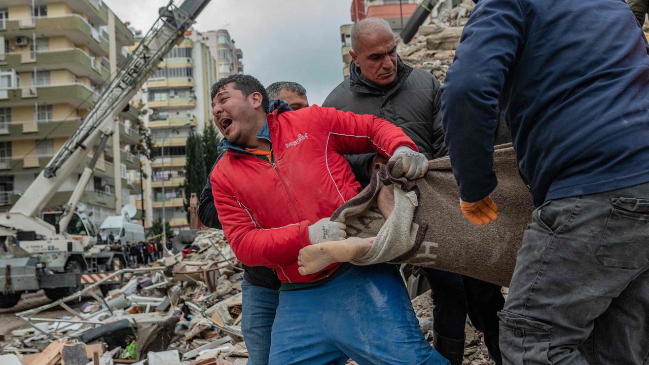 TOPSHOT - A rescuer reacts as he carries a body found in the rubble in Adana on February 6, 2023, after a 7.8-magnitude earthquake struck the country's south-east. - The combined death toll has risen to over 1,900 for Turkey and Syria after the region's strongest quake in nearly a century on February 6, 2023. Turkey's emergency services said at least 1,121 people died in the 7.8-magnitude earthquake, with another 783 confirmed fatalities in Syria, putting that toll at 1,904. (Photo by Can EROK / AFP)