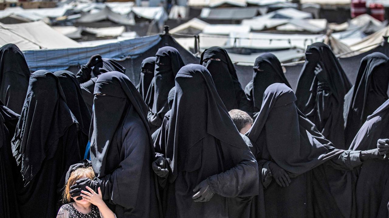 Women and a child queue to receive humanitarian aid packages at the Kurdish-run al-Hol camp, which holds relatives of suspected Islamic State (IS) group fighters. Picture: Delil Souleiman/AFP