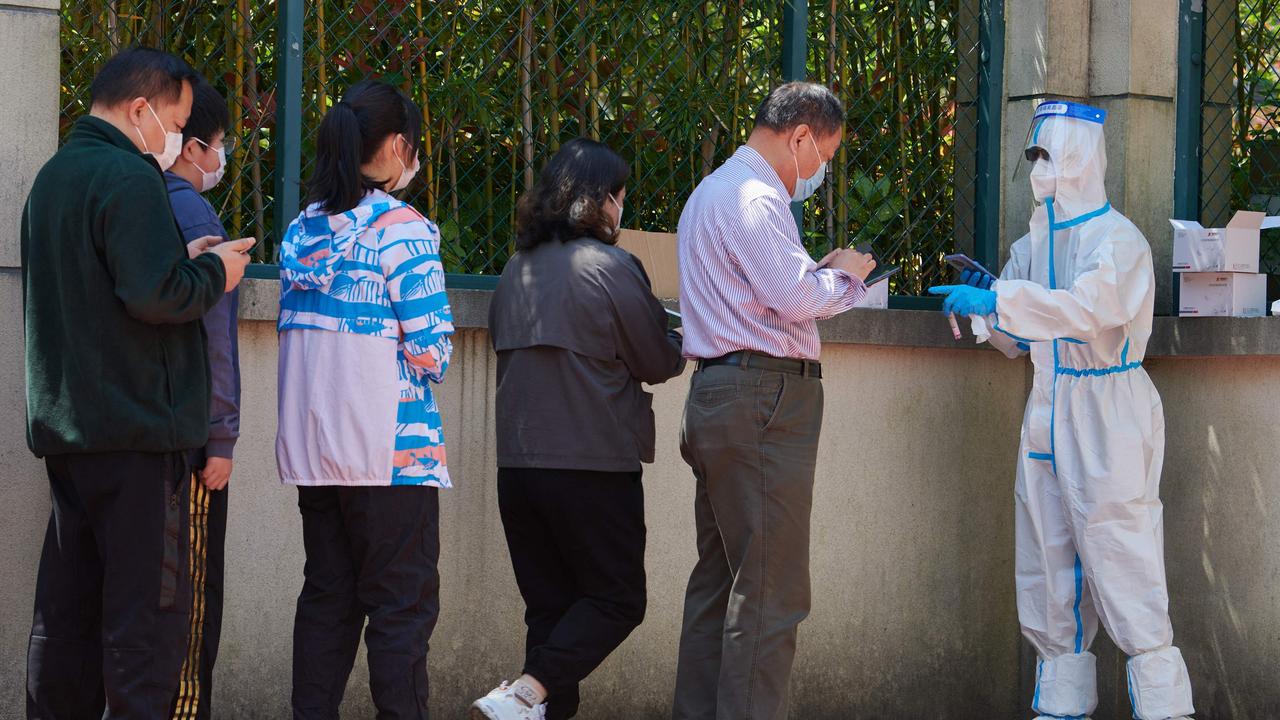 A community volunteer (R) wearing personal protective equipment registers residents before testing for the Covid-19 coronavirus in a compound. Picture: Liu Jin/AFP