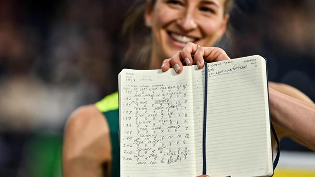 First-placed Australia's Nicola Olyslagers shows her notes as she celebrates after competing in the Women's High Jump final during the Indoor World Athletics Championships in Glasgow, Scotland, on March 1, 2024. (Photo by Ben Stansall / AFP)