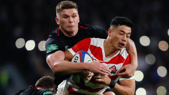 Japan winger Akihito Yamada is tackled by England's fly half Owen Farrell.