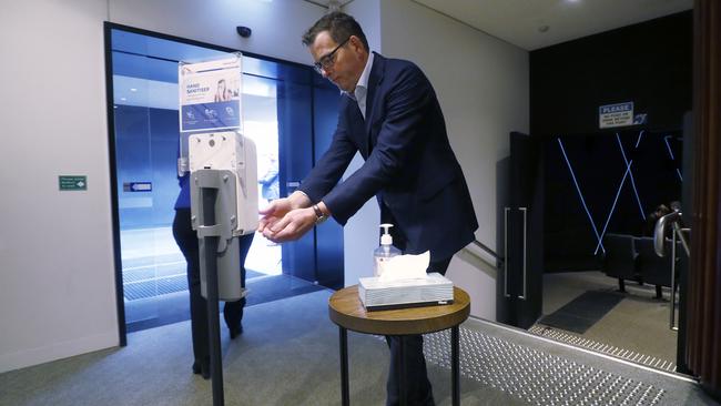 Victorian Premier Daniel Andrews sanitises his hands after speaking to the media during his Friday daily briefing. Picture: Getty Images