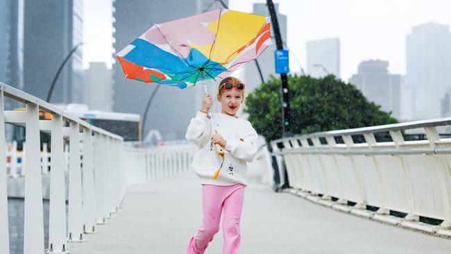 7 year old Olivia Auer from Tanah Merah didn’t let the rain stop her day out in the city. Picture: Lachie Millard