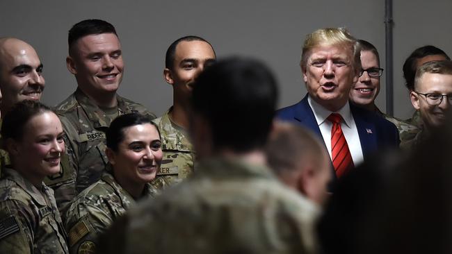 Mr Trump poses for pictures with soldiers during his surprise Thanksgiving day visit. Picture: AFP