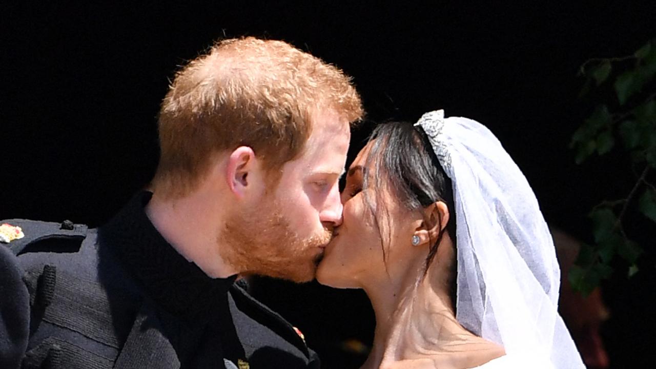 Britain's Prince Harry, Duke of Sussex kisses his wife Meghan, Duchess of Sussex as they leave from the West Door of St George's Chapel, Windsor Castle, in Windsor, on May 19, 2018 after their wedding ceremony. Picture: AFP