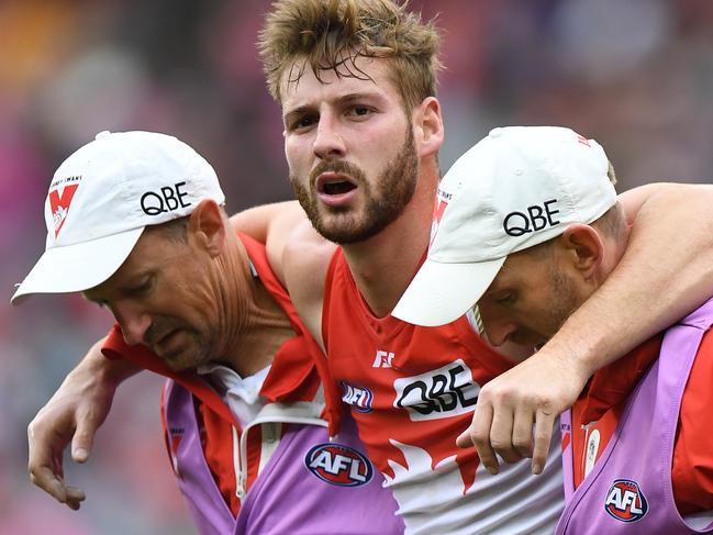 Alex Johnson of the Swans (centre) is seen after sustaining an injury during the Round 21 AFL match between the Melbourne Demons and the Sydney Swans at the MCG in Melbourne, Sunday, August 12, 2018. (AAP Image/Julian Smith) NO ARCHIVING, EDITORIAL USE ONLY