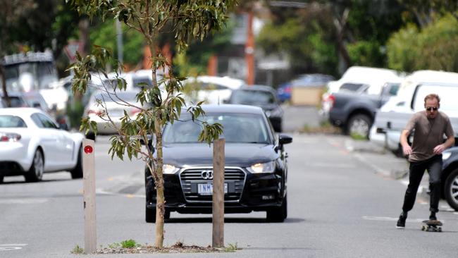 Cars and other road users navigate around freshly-planted trees along Mater Street Collingwood. Picture: Andrew Henshaw