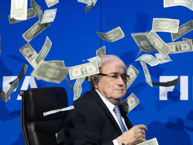 FIFA president Sepp Blatter looks on as fake dollar notes fly around him, thrown by a British comedian during a press conference at the FIFA world-body headquarter's in Zurich. Picture: Fabrice Coffrini / AFP