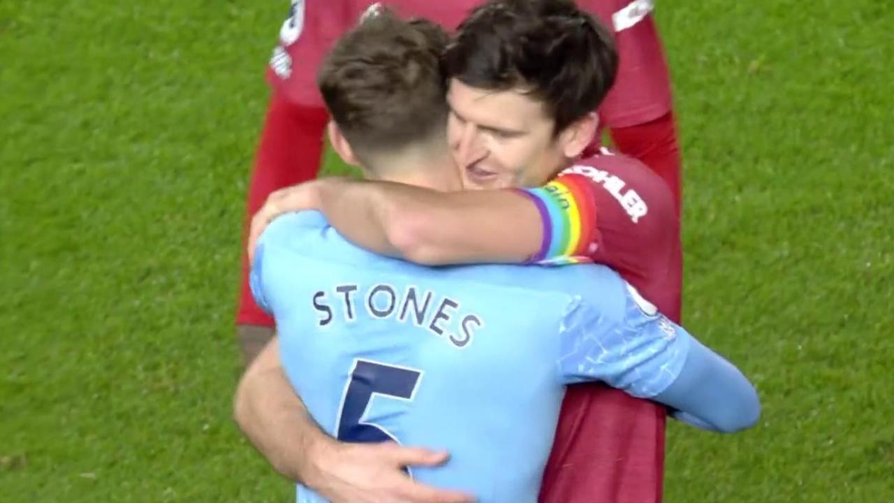 Manchester United and Manchester City players hug post-game.