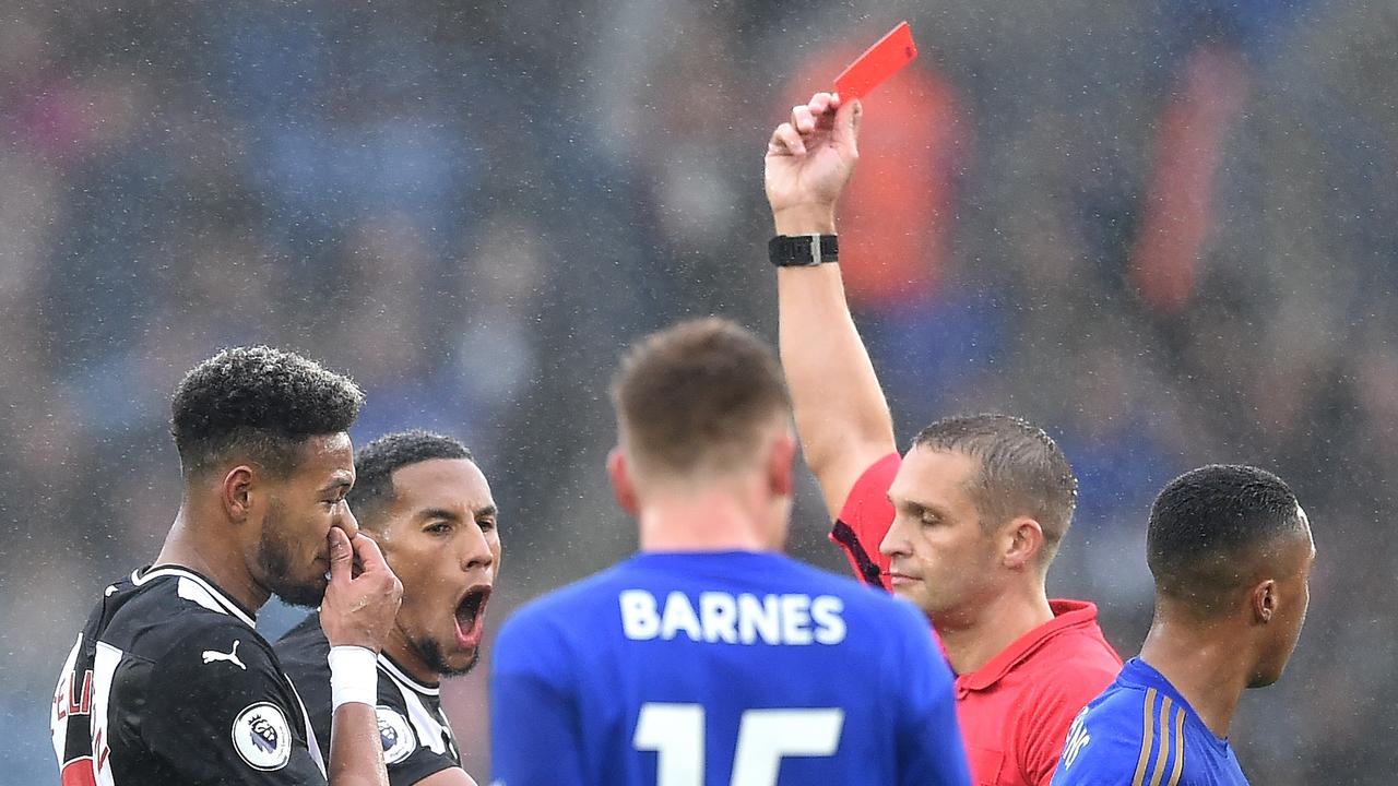 Referee Craig Pawson shows a red card to Isaac Hayden