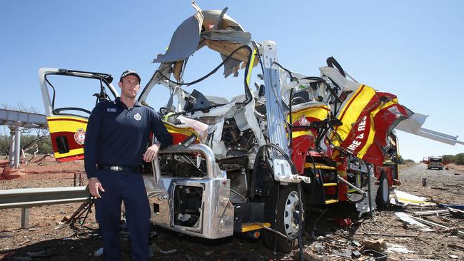 Constable Kenric Head next to the fire truck which was first on scene after a truck rollover on the Mitchell Highway.