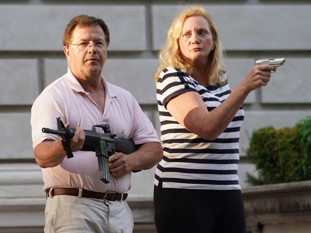 A husband and wife hold a pistol and automatic rifle as protesters walk past their house en route to St. Louis Mayor Lyda Krewson's home during a protest march in St. Louis on Sunday, June 28, 2020. Picture: Bill Greenblatt/UPI/Alamy Live News