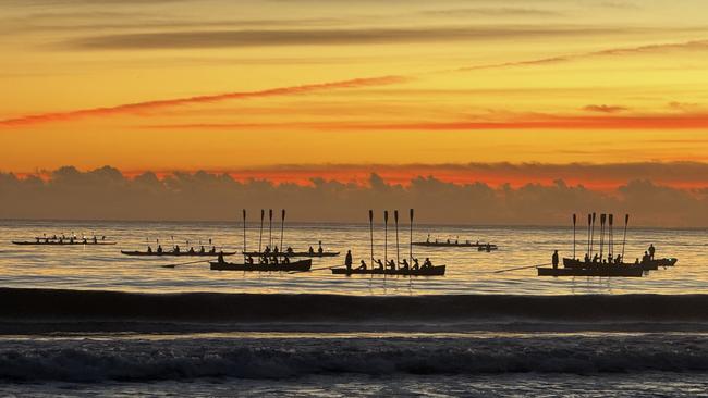 Molooloaba Surf Boats raise their oars in salute as part of the Dawn Service. Photo: Mark Furler