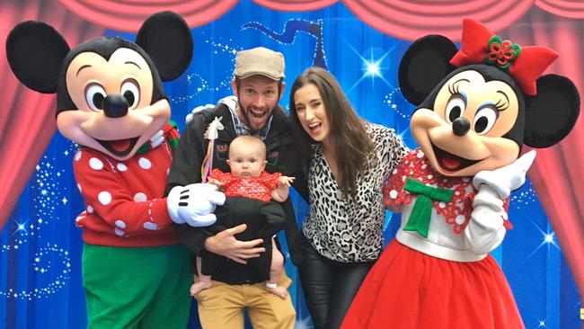 Aviana McElwee, with mum Bethan and dad Jonathan, meeting Mickey and Minnie at Carols by Candlelight at The Domain in Sydney, the night before her surgery. Picture: Supplied